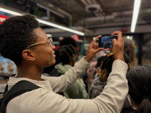 intern taking picture of students at the makerspace